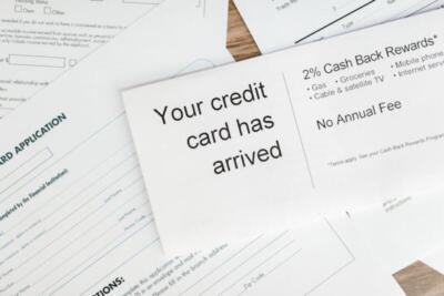 Close-up of a letter announcing the arrival of a credit card amidst financial documents.
