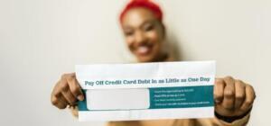 Woman presenting an envelope with a credit card debt offer, blurred background.